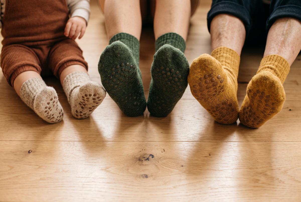 Pieds d'un enfant, d'un adulte et d'une personne âgée en chaussettes antidérapantes Image