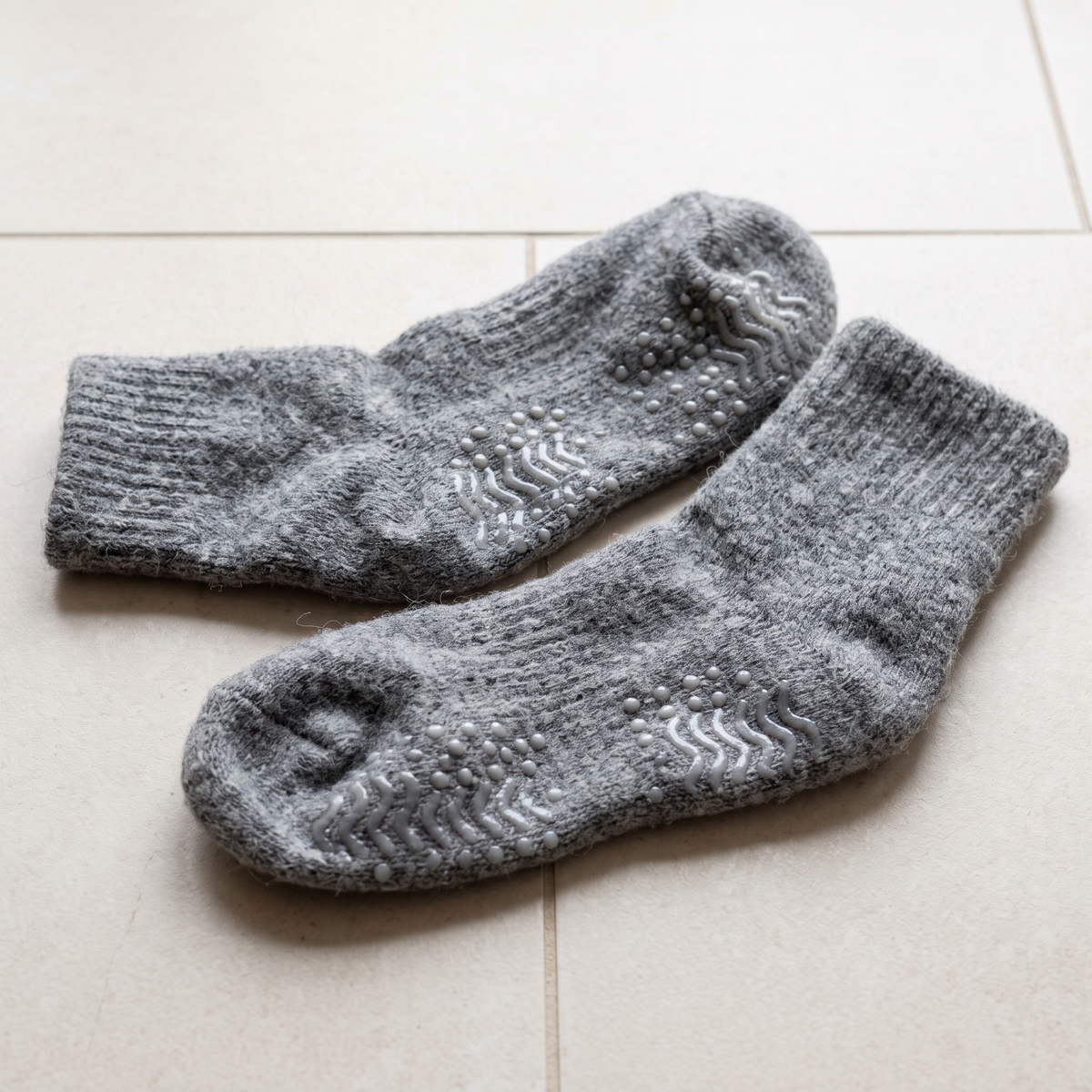 Semelle picotée de chaussettes antidérapantes grises sur un carrelage